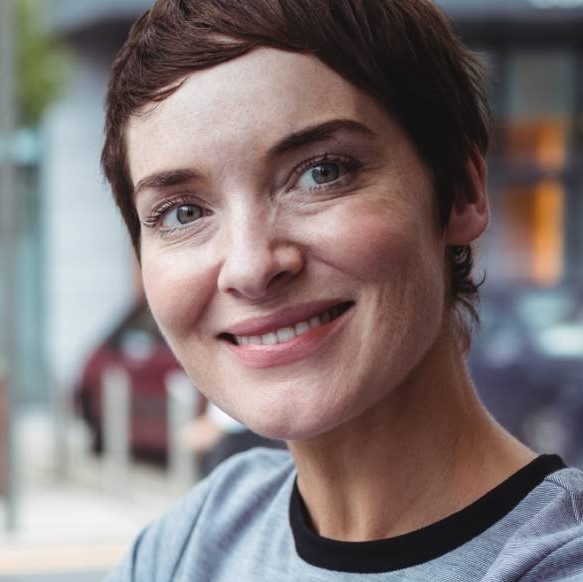 Portrait of businesswoman using digital tablet while having coffee in office